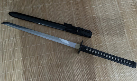 A full view of the unsheathed Obsidian Gale Ninja Sword next to its gloss-black hardwood saya.