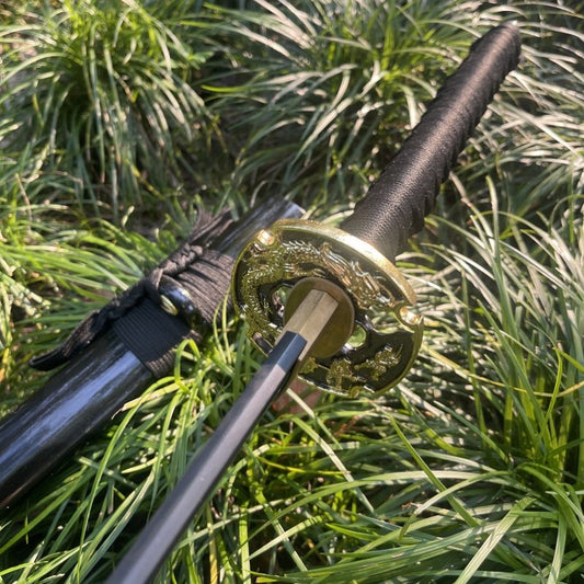 The Obsidian Edge Katana with its blackened folded 1095 steel blade, crossed over its gloss-black saya outdoors.