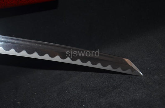 A close-up of the Sakabatō's manganese steel blade, showing the real clay-tempered hamon on the reverse edge.