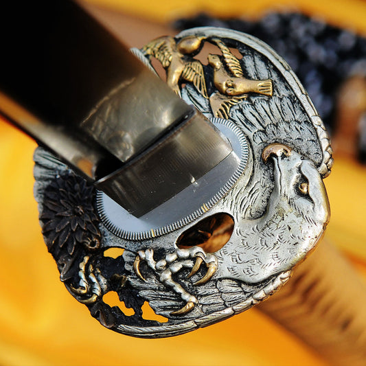 A detailed macro shot of the Taka's Sky Katana, showcasing the intricately carved copper "Taka" (Eagle) theme tsuba.