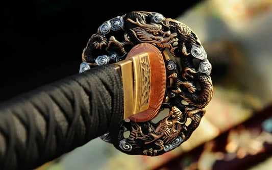 A close-up of the brass tsuba (guard) of the Raden Ryū Katana, featuring a detailed Dragon (Ryū) theme.