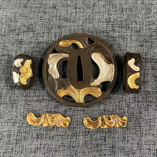 Gilded and silvered brass Koshirae set with an abstract flowing leaves motif on a Sukashi Tsuba and matching Fuchi, Kashira, and Menuki.