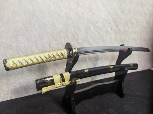 The unsheathed Lightning Vein Wakizashi on a stand, showing its folded steel blade with twin grooves.