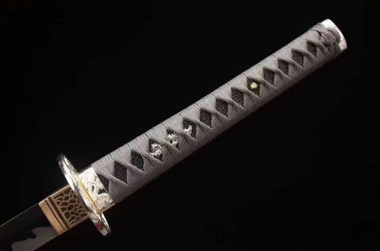 A detailed view of the tsuka, featuring the grey silk/cotton ito wrap, white rayskin, and silver alloy tsuba.