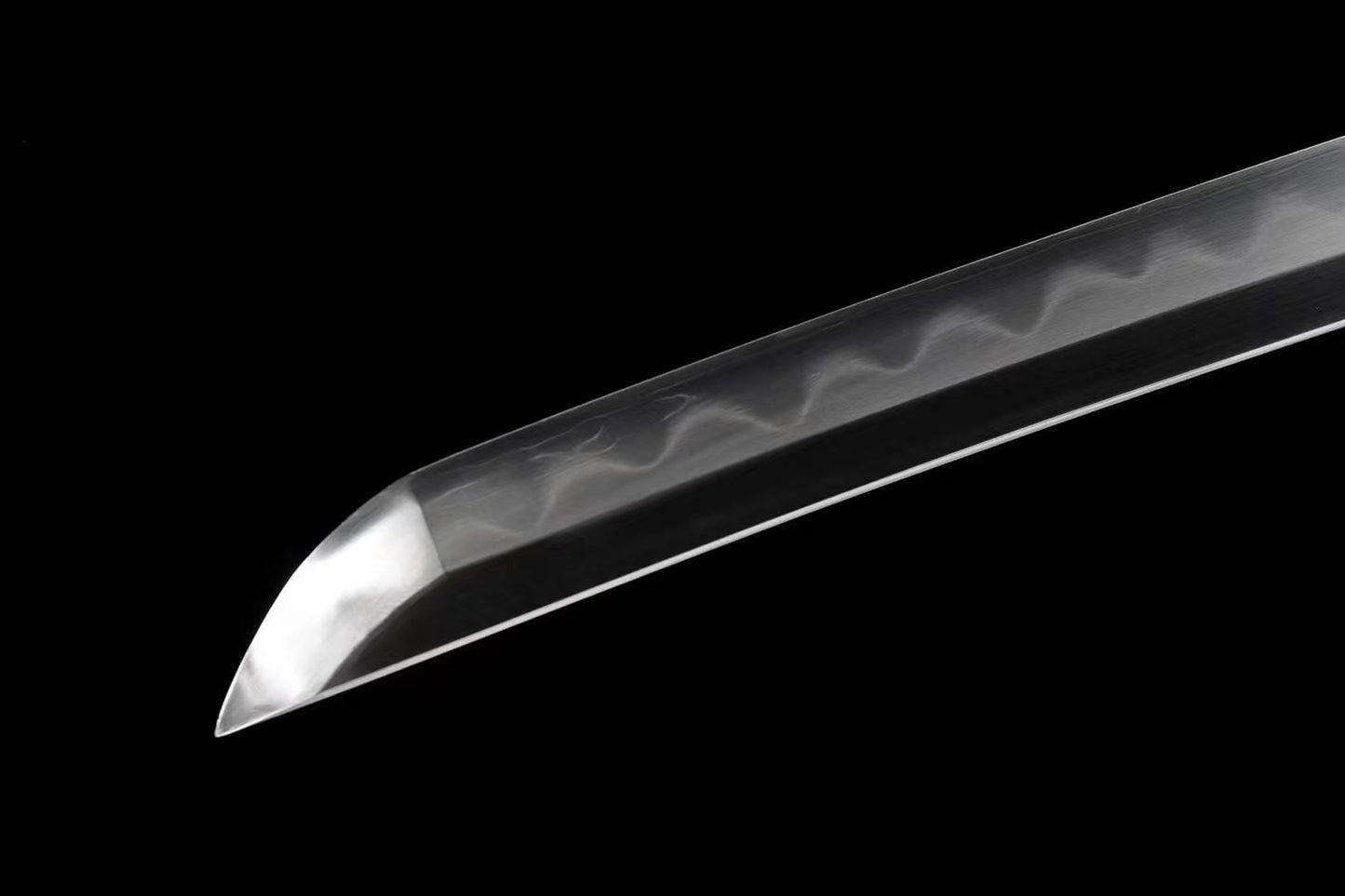 A detailed shot of the sharp chu-kissaki tip of the Honsanmai laminated, folded steel blade.