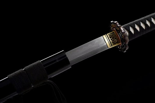 A detailed view of the brass habaki at the base of the Honsanmai laminated, folded steel blade.