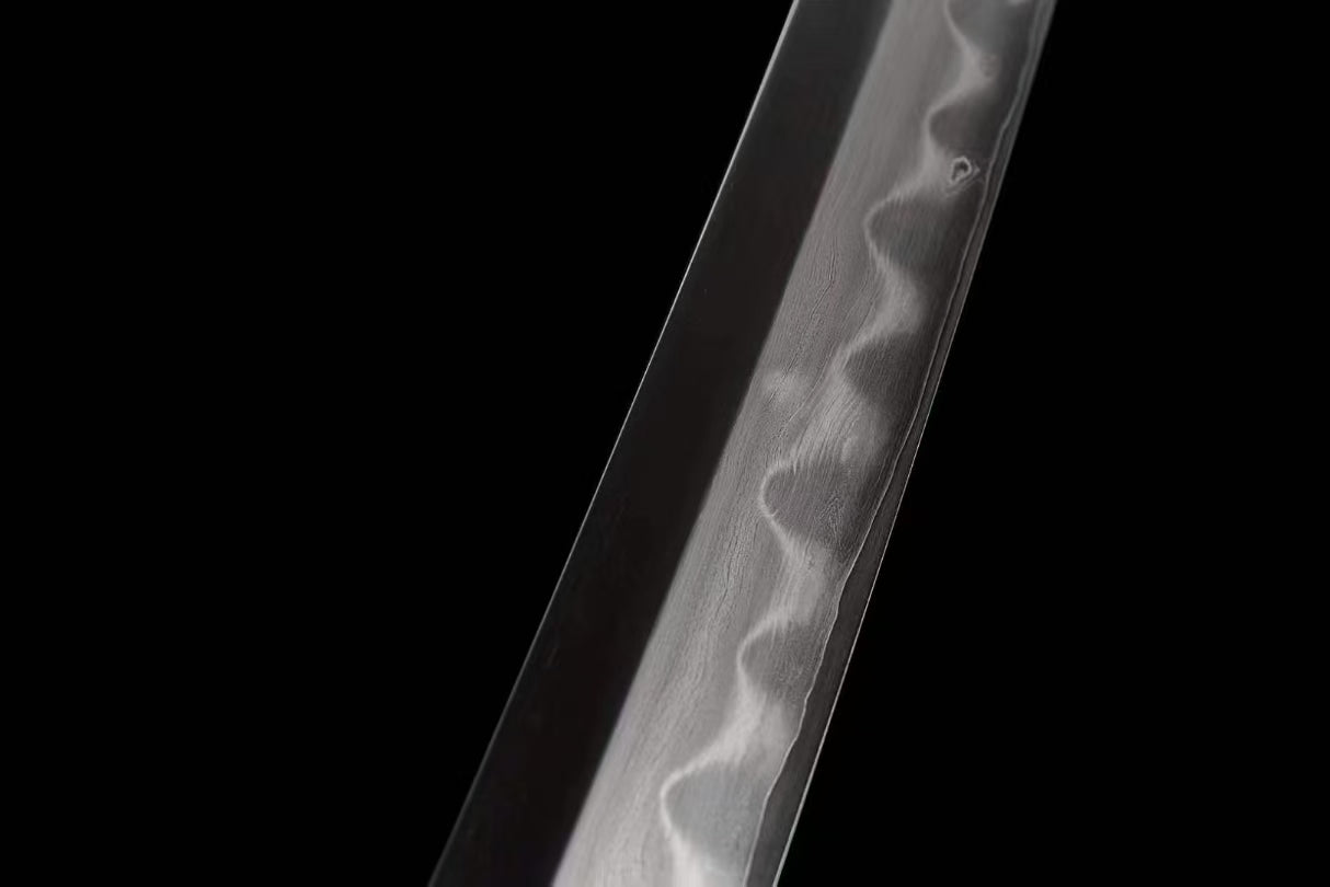 A close-up of the Honsanmai blade, showcasing the folded steel pattern (hada) and the real clay-tempered hamon.