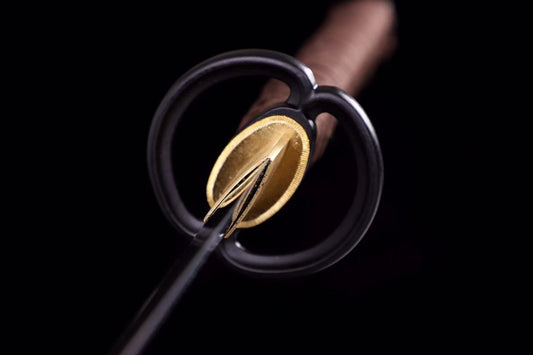 A detailed close-up of the simple, functional round iron tsuba on the Dusklight Fang Katana.