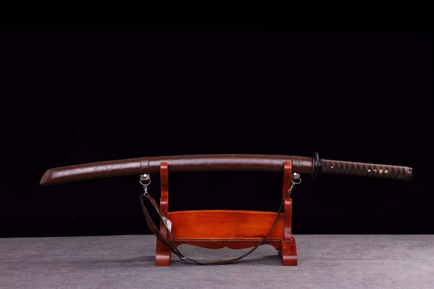 An alternate angle of the sheathed Dusklight Fang Katana, highlighting the texture of the brown leather saya.