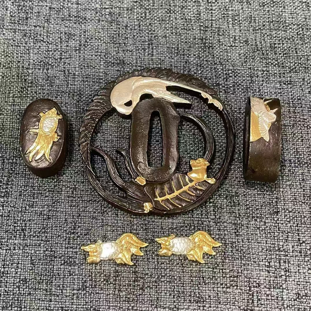 Complete Koshirae set featuring a silvered Sagi (heron) and gilded Shishi (lion) on a textured black brass Sukashi Tsuba, with matching dual-tone Fuchi, Kashira, and Menuki.