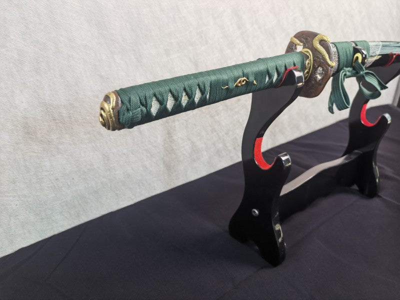 A detailed view of the brass kashira (pommel) with a serpent theme at the end of the tsuka handle.