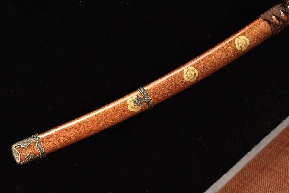 A close-up of the saya, showing the detailed gold and dark brown speckled lacquer finish.