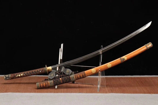 The unsheathed Shogun's Golden Tachi with its T10 steel blade crossed over the saya on a display stand.