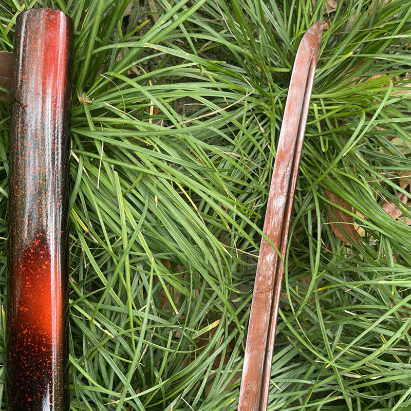 A macro shot of the unique "Folded Red" 1095 high-carbon steel blade of the Inferno Blade Katana.