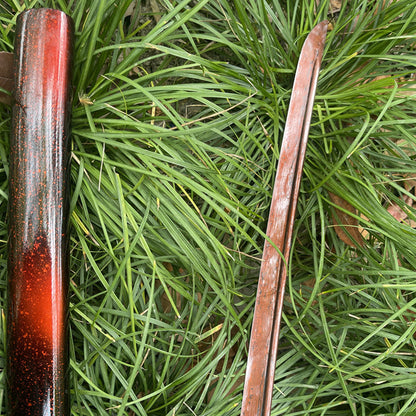 A macro shot of the unique "Folded Red" 1095 high-carbon steel blade of the Inferno Blade Katana.
