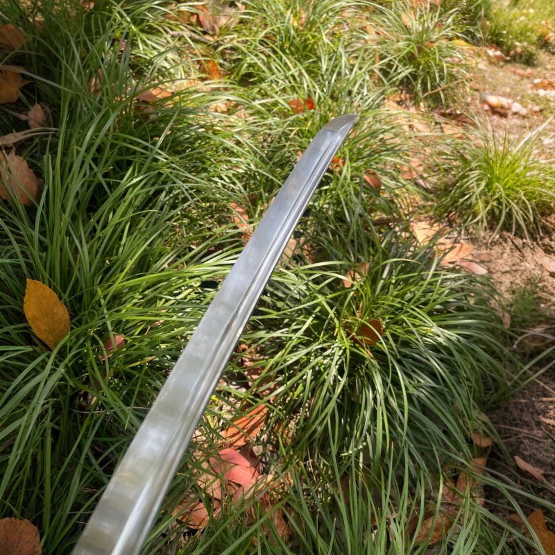 A detailed shot of the hand-forged 1095 high-carbon steel blade of the Silent Vein Katana.