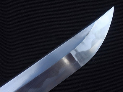 A detailed macro shot of the chu-kissaki tip, highlighting the flawless hand-polished mirror finish on the 1095 steel blade.