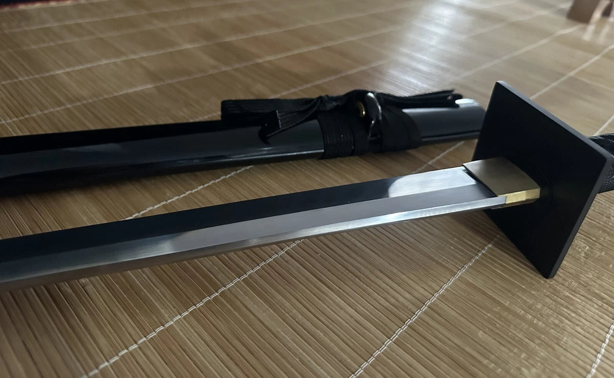 The Obsidian Gale Ninja Sword partially drawn, revealing the hand-forged 9260 spring steel straight blade.