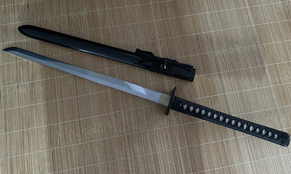 A full view of the unsheathed Obsidian Gale Ninja Sword next to its gloss-black hardwood saya.