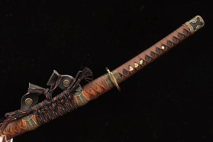 A close-up of the tsuka handle, featuring the dark brown silk ito wrap and antique-finish copper tsuba.