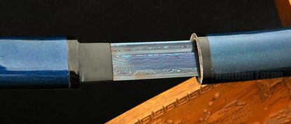 The Aurora Steel Blue Shirasaya partially drawn, revealing the Damascus folded steel blade.