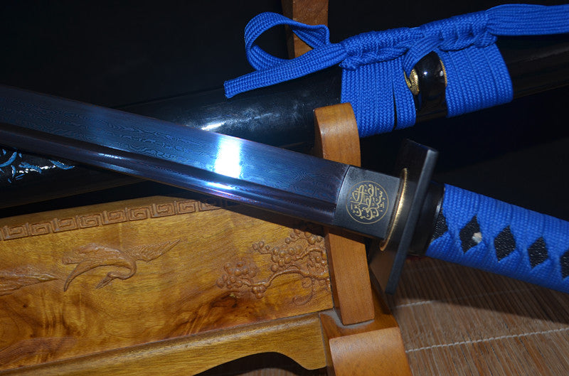 The Seiryu's Blade Katana partially drawn, revealing the blue folded steel blade and the engraved brass habaki.