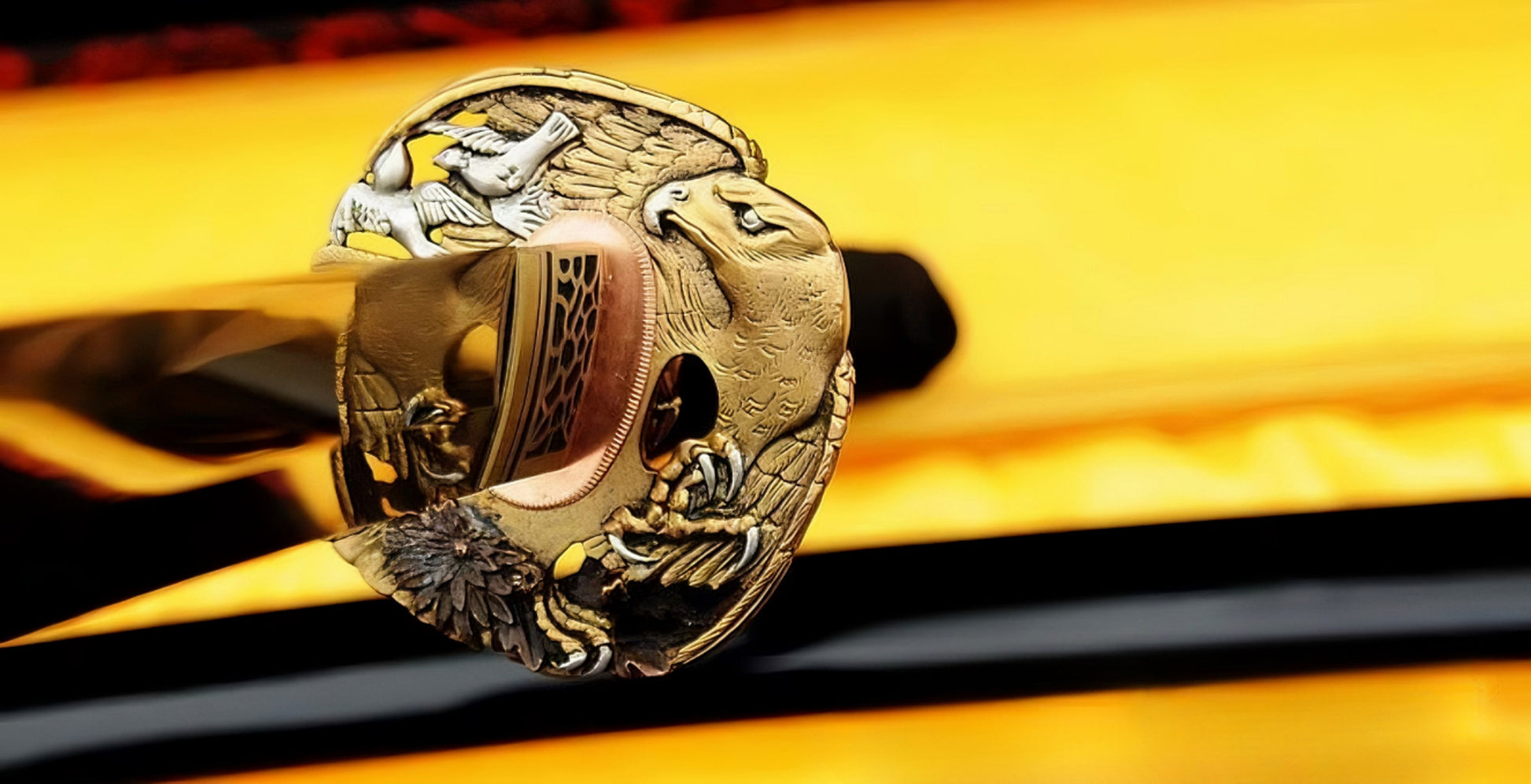 A close-up of the Golden Hawk Katana, showing the intricate brass habaki and the "Golden Hawk" theme fuchi (hilt collar) at the base of the handle.