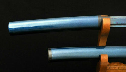 A detailed view of the kojiri (end cap), crafted from genuine buffalo horn, on the metallic blue saya.