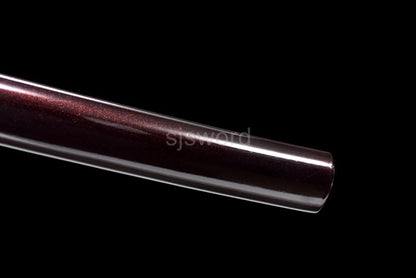 A detailed view of the kojiri (end cap) of the saya, showing the burgundy red speckled lacquer finish.