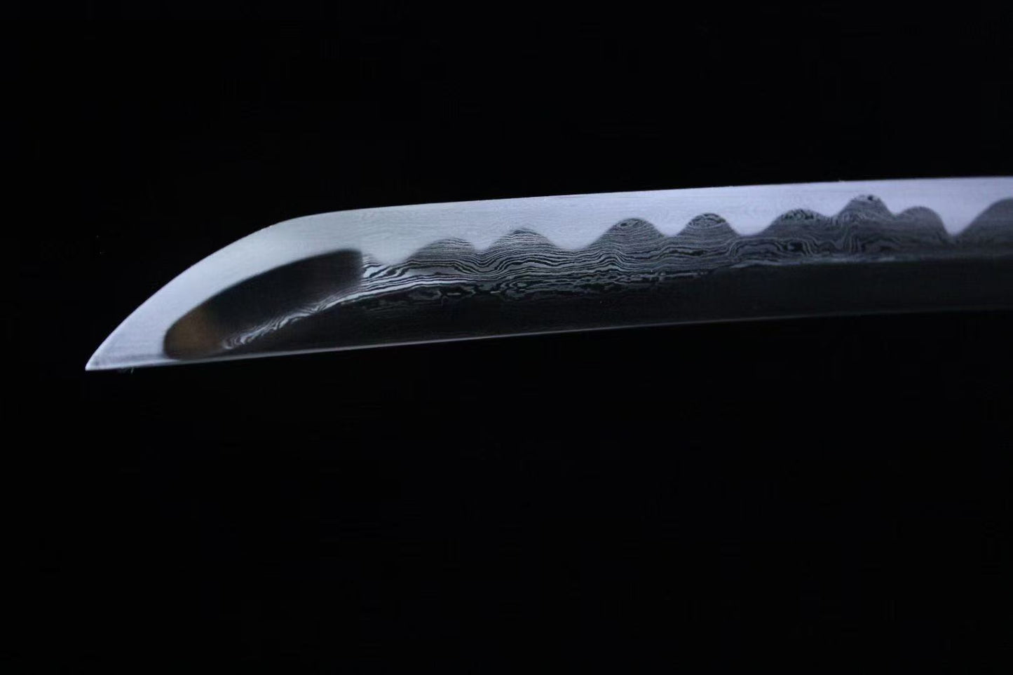 A close-up of the folded steel blade, clearly showing the authentic wavy clay-tempered hamon.