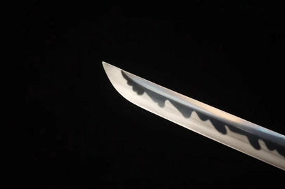 A sharp, clear close-up of the chu-kissaki tip of the T10 steel blade, showing the real clay-tempered hamon.