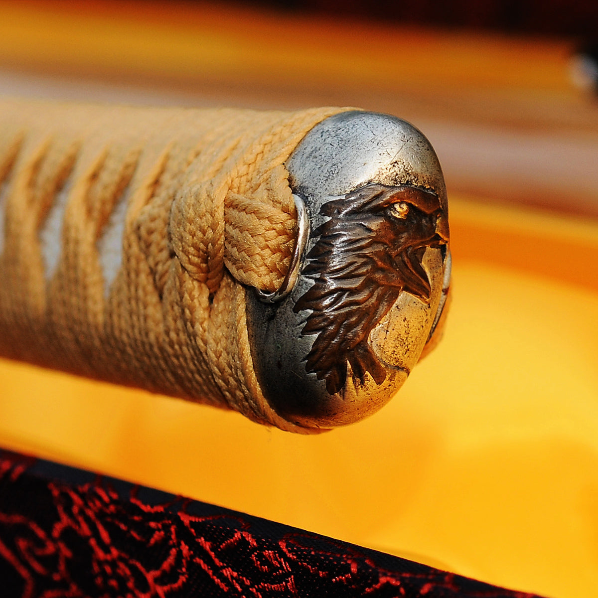 A detailed macro shot of the Taka's Sky Katana's kashira (pommel), showcasing the intricately carved copper "Taka" (Eagle) head.