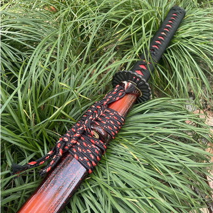 A comparison shot showing the "Folded Red" blade next to the black-to-red speckled lacquer of the saya.