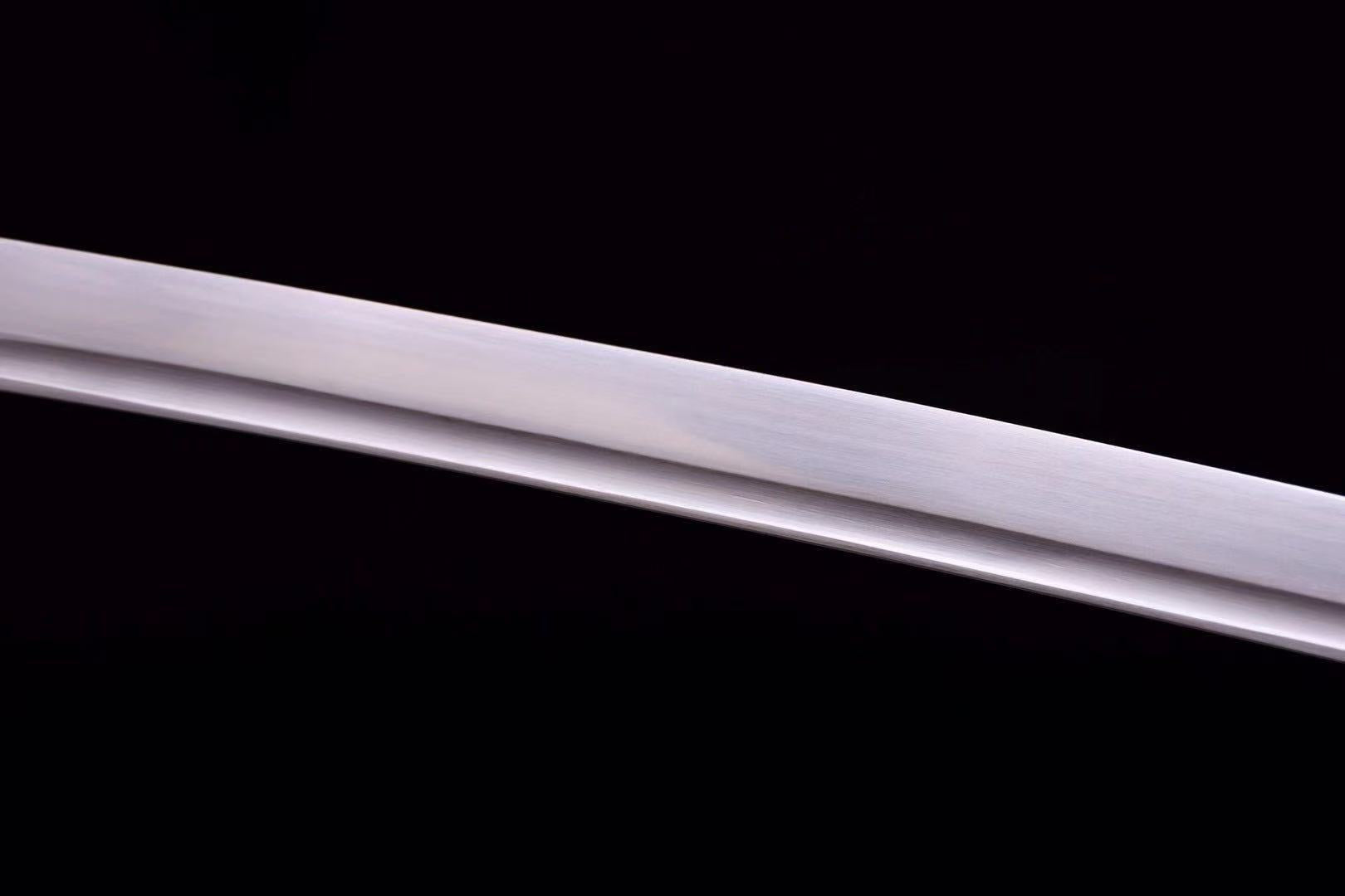 A macro shot of the blade, showcasing the beautiful grain pattern (hada) of the hand-forged folded steel.