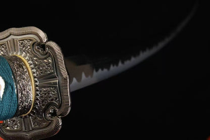 A close-up showing the base of the folded steel blade, brass habaki, and the real clay-tempered hamon.