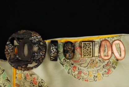 The complete set of antique-finish, gilded "Shishi" (Guardian Lion) theme koshirae fittings for the Sennin's Guardian Katana, displayed on a silk bag.