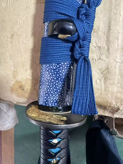Close-up of the blue rayskin saya panel with blue sageo cord and black kurigata