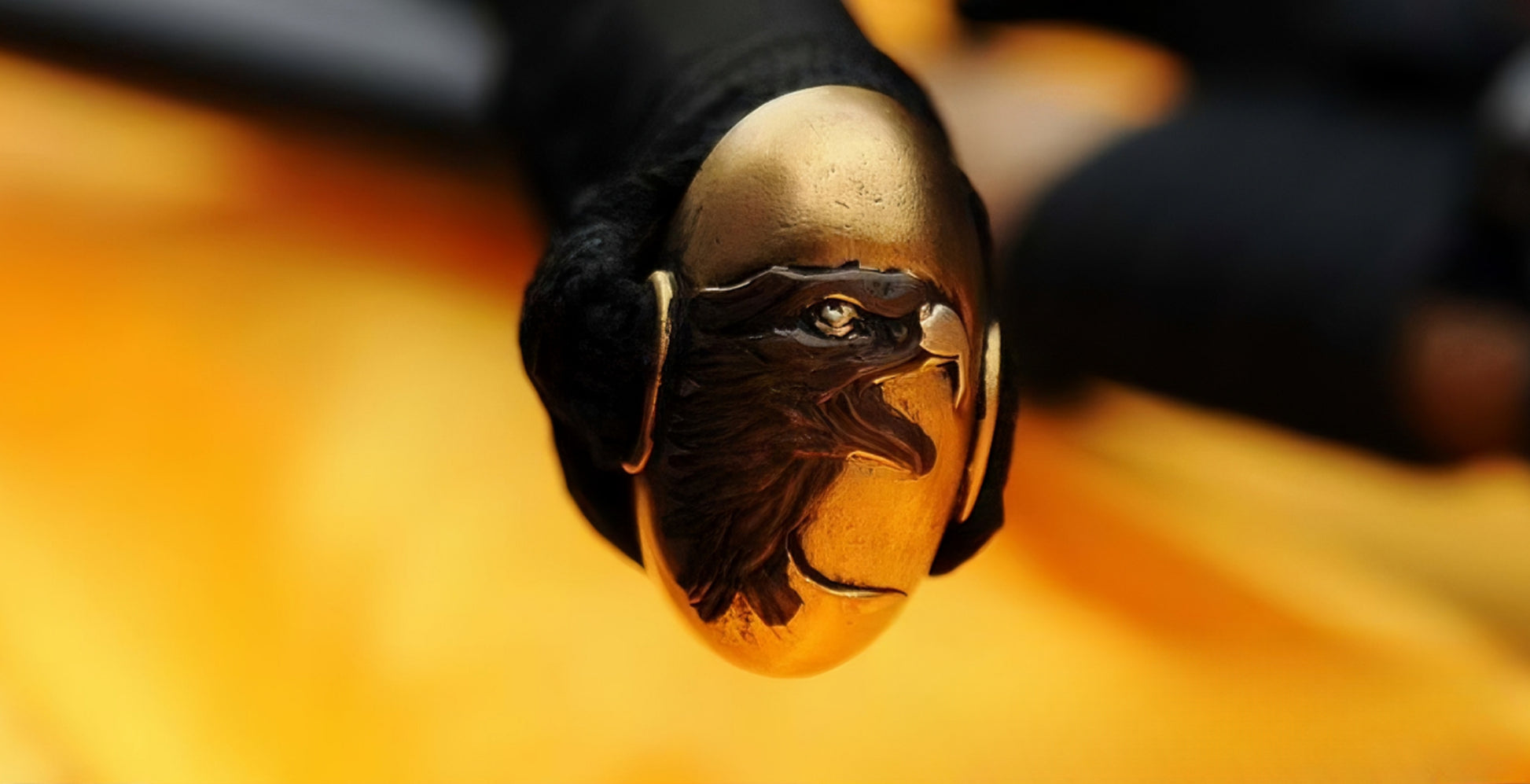 A detailed macro shot of the kashira (pommel) of the Golden Hawk Katana, featuring the masterfully sculpted "Golden Hawk" head in solid brass.