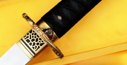 A detailed macro shot of the Golden Hawk Katana's tsuba (guard), showcasing the masterfully sculpted "Golden Hawk" (Taka) theme in solid brass.