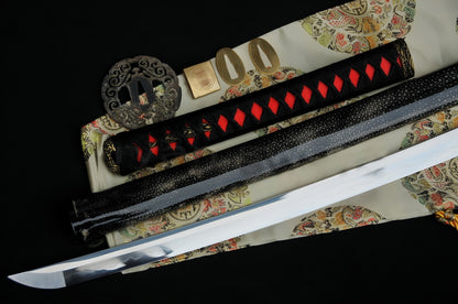 A flat-lay of the Crimson Tide Katana, showcasing the T10 steel blade, red rayskin tsuka, and disassembled brass "Great Wave" fittings.