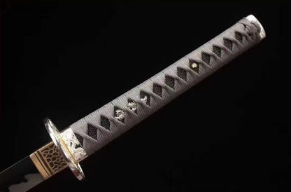 A detailed view of the tsuka, featuring the grey silk/cotton ito wrap, white rayskin, and silver alloy tsuba.