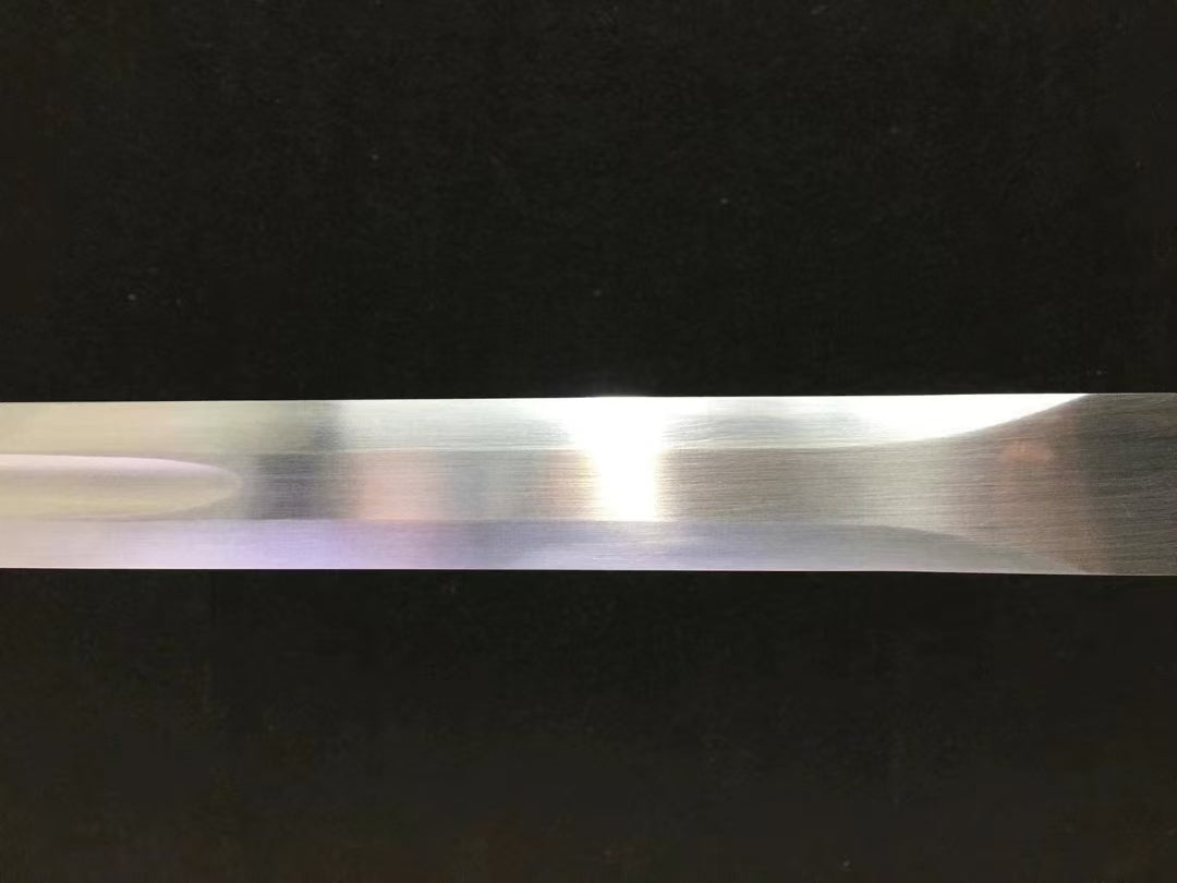 A macro shot of the hand-forged, through-hardened high carbon steel blade of the Green Phantom Ninja Sword.