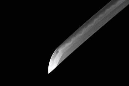 A detailed shot of the sharp chu-kissaki tip of the Honsanmai laminated, folded steel blade.