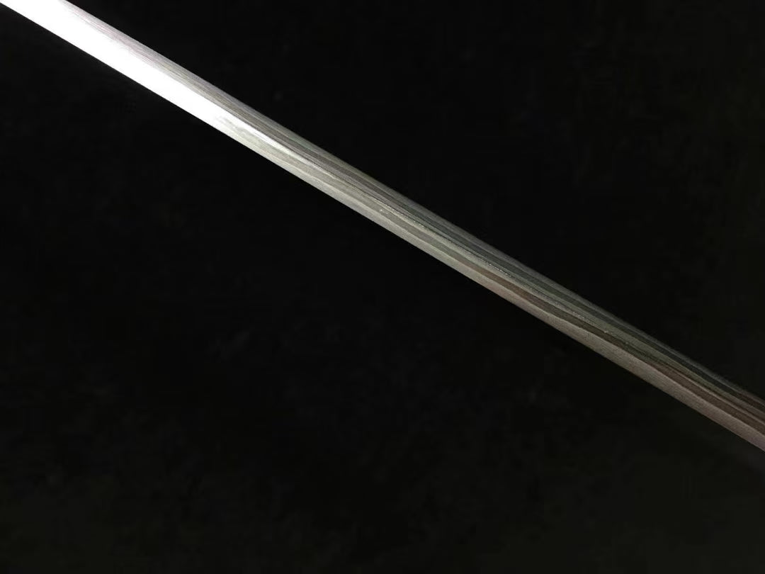 A full-length view of the hand-forged Honsanmai blade, displaying the bo-hi (groove) and its curvature.