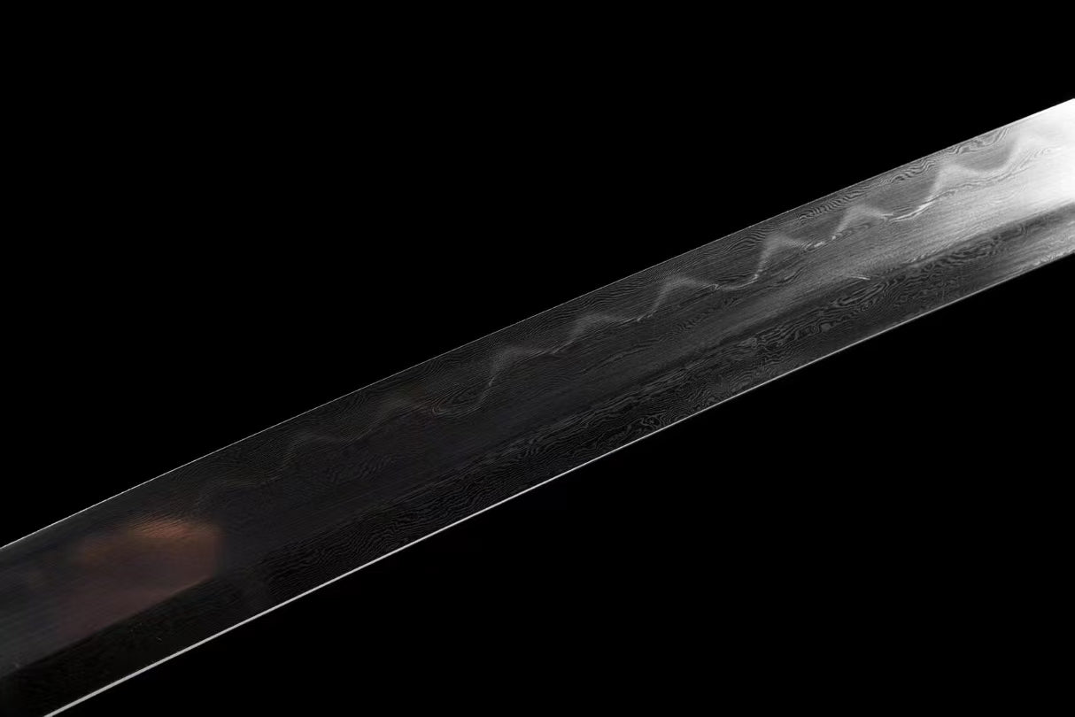 A close-up of the Honsanmai blade, showcasing the folded steel pattern (hada) and the real clay-tempered hamon.