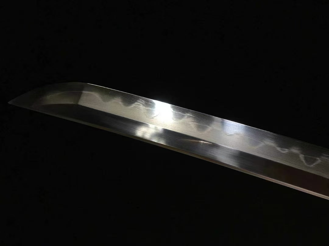 A detailed shot of the Honsanmai laminated and folded steel blade, showing the real clay-tempered hamon.