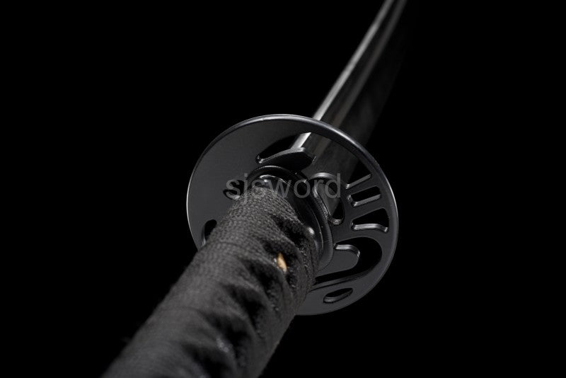 A top-down view looking past the iron bloom tsuba towards the brass habaki and blackened blade.