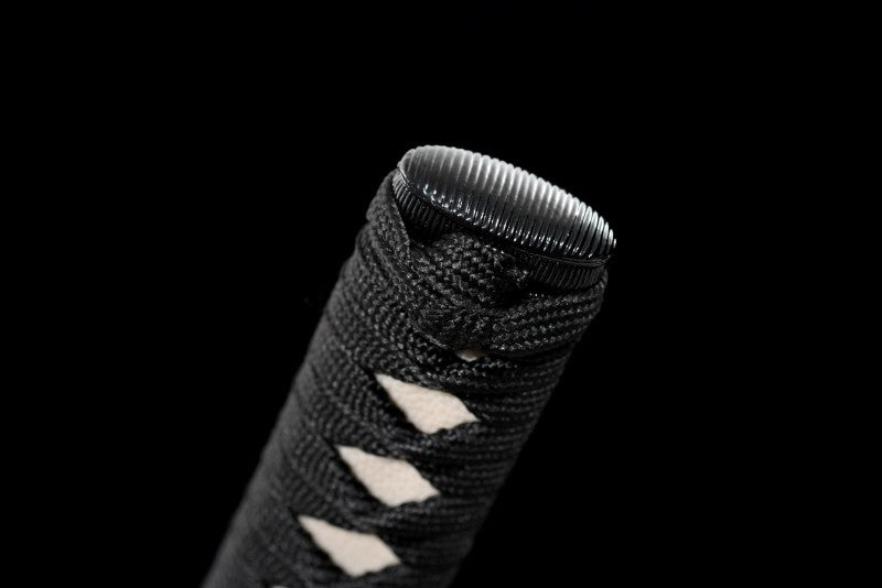 A detailed close-up of the kashira (pommel) and the knot on the black ito wrap.