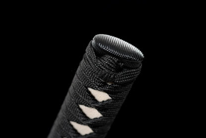 A detailed close-up of the kashira (pommel) and the knot on the black ito wrap.