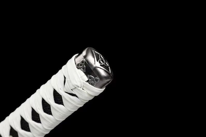 A detailed close-up of the kashira (pommel) and the knot work on the white leather ito handle.